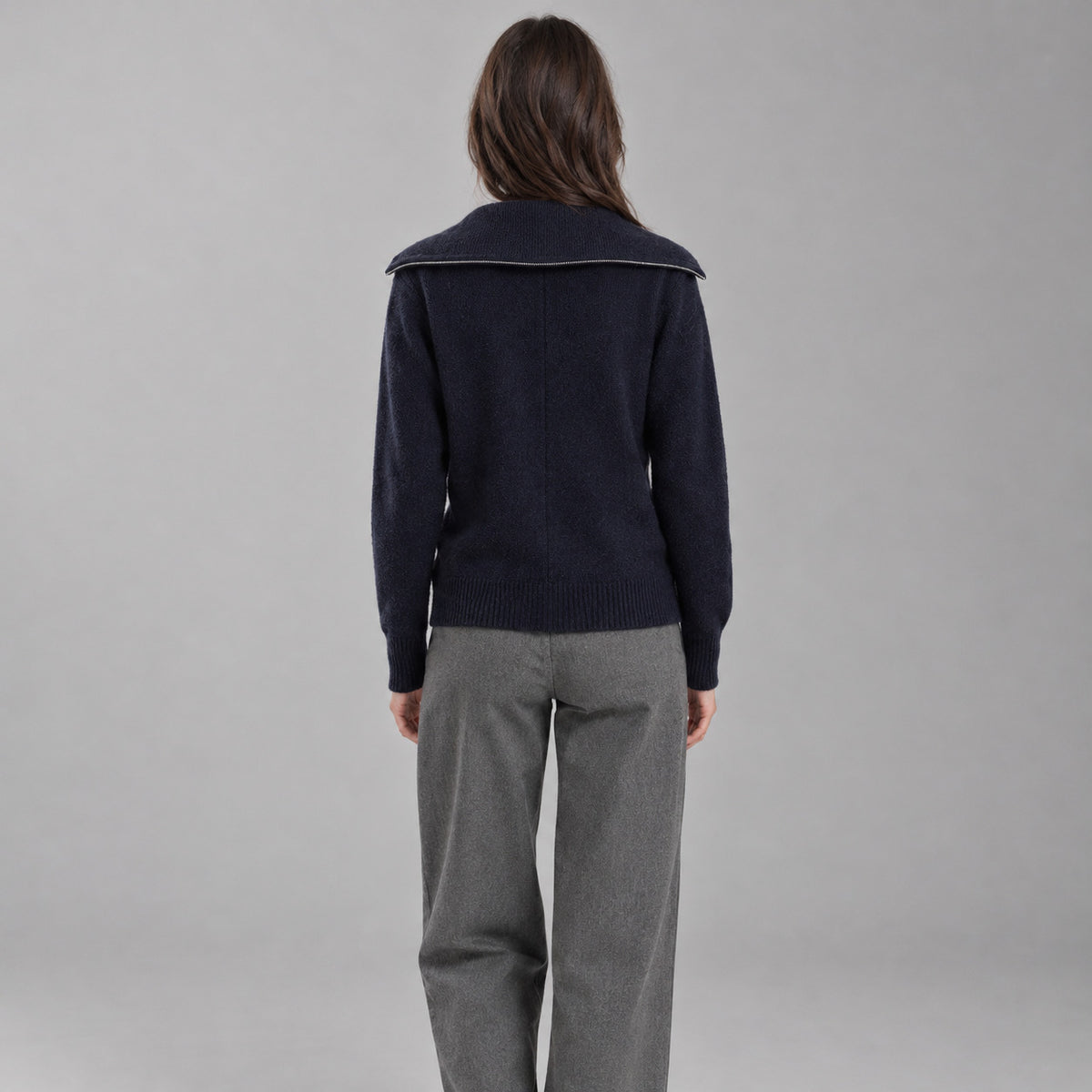 Back of the navy blue zip-front cashmere cardigan worn, showing the centre back seam.
