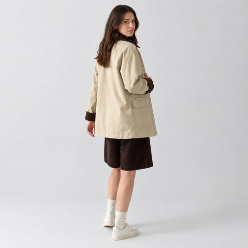 Light beige barn jacket with corduroy collar worn by a model in a neutral studio.