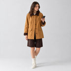 Ginger yellow barn jacket with corduroy collar worn by a model in a neutral studio.