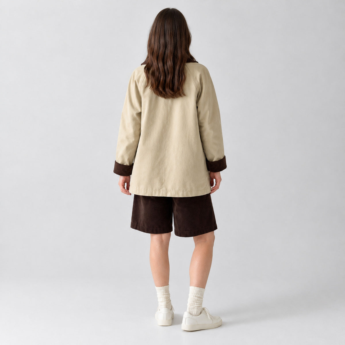 Back of the light beige barn jacket worn, showing the raglan sleeve seams.