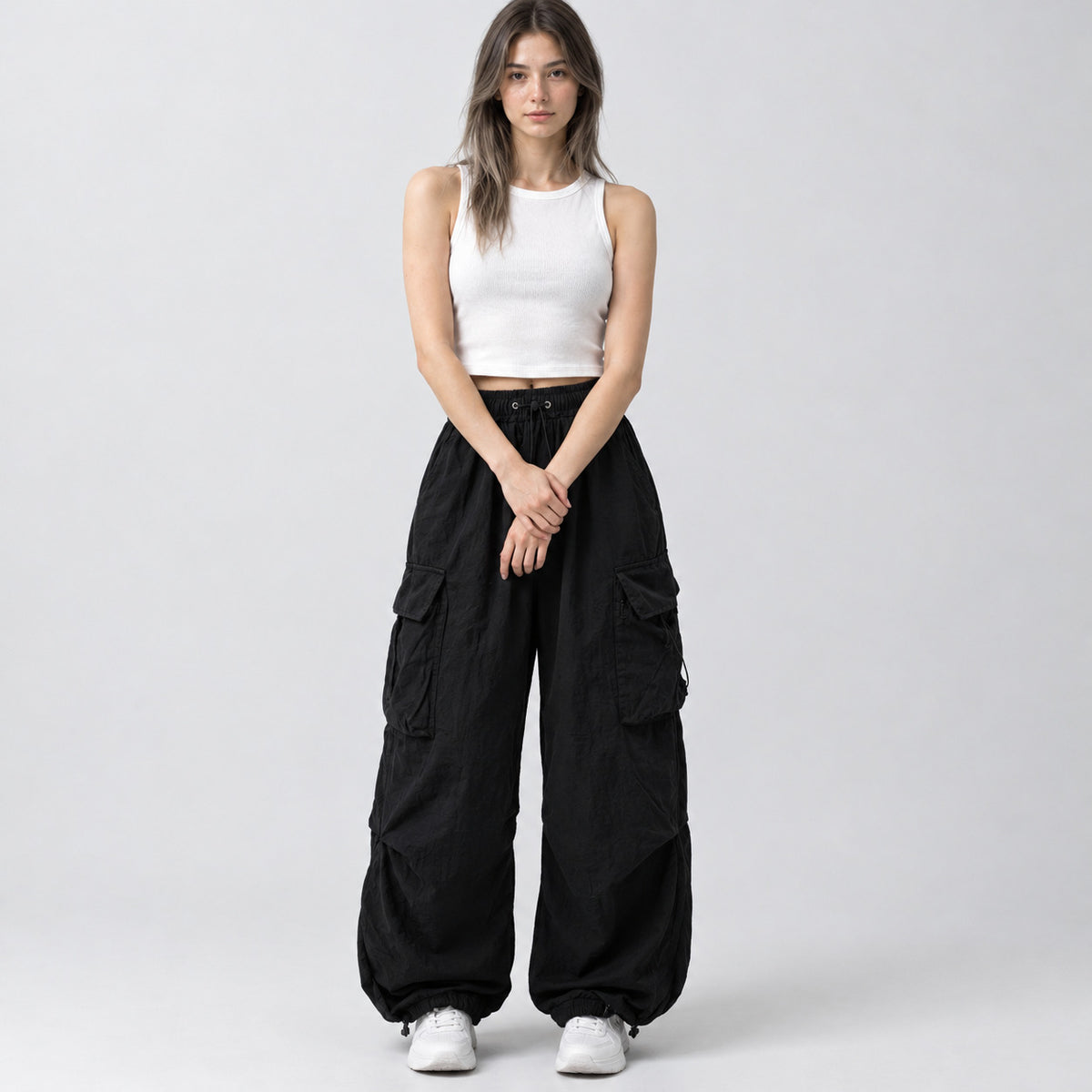 Black wide-leg parachute cargo pants worn by a model in a neutral studio setting.