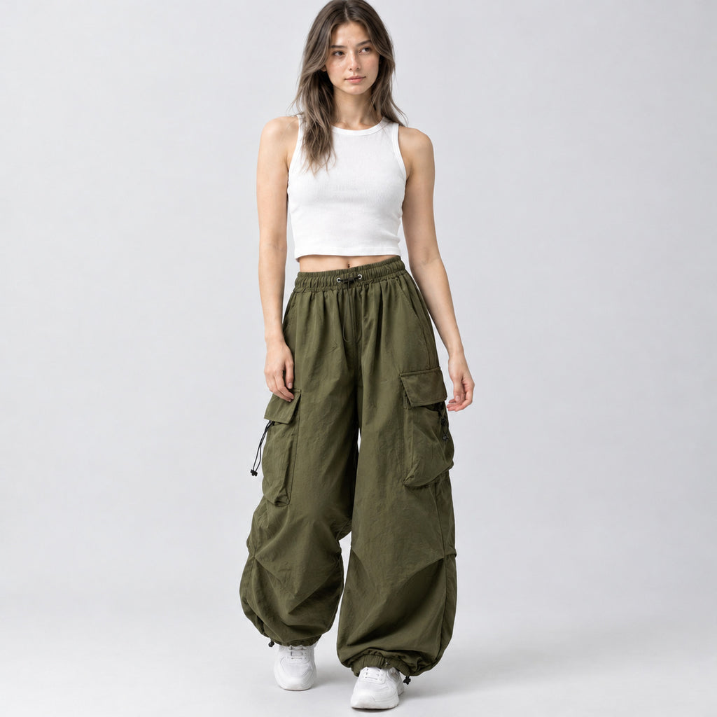 Army green wide-leg parachute cargo pants worn by a model in a neutral studio setting.