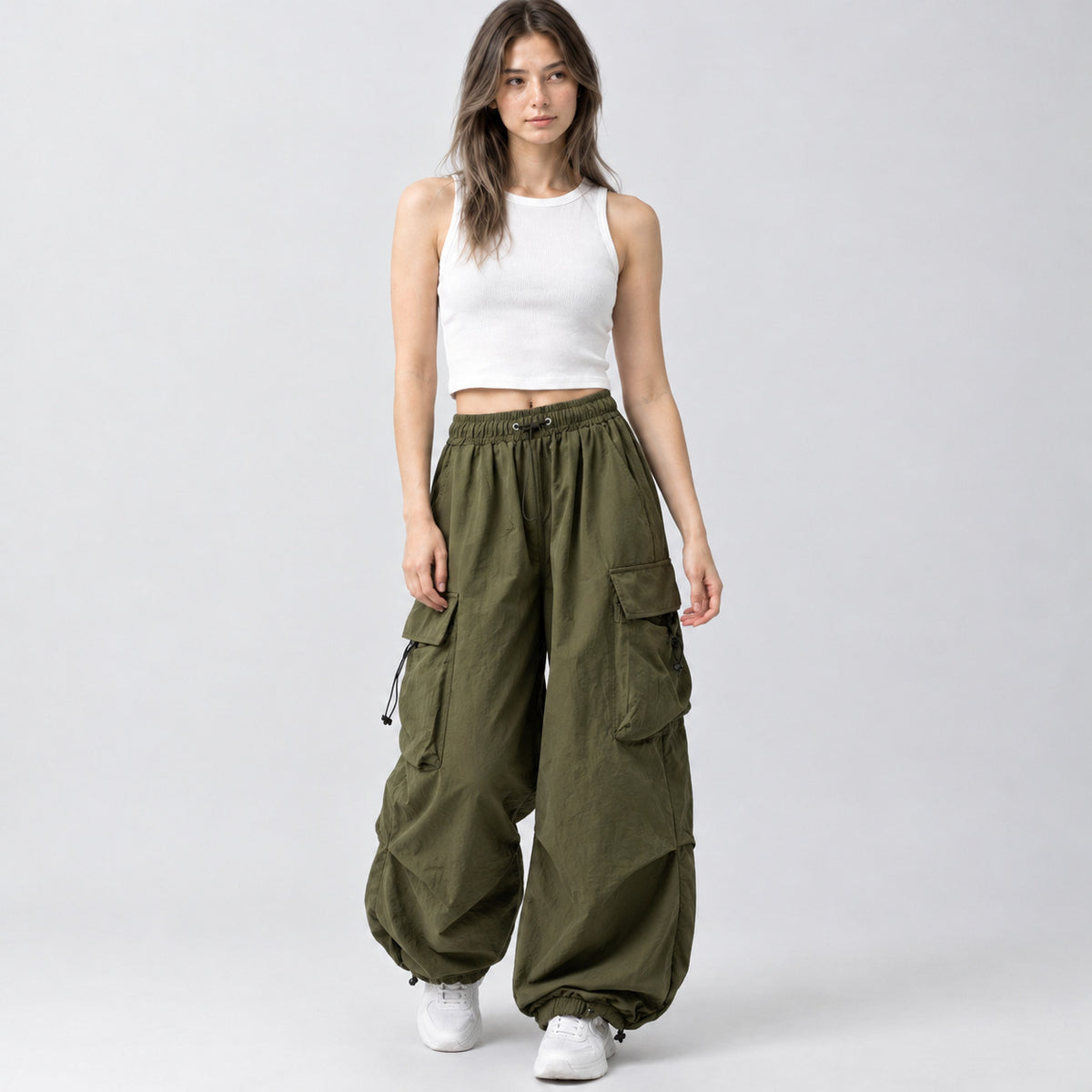 Army green wide-leg parachute cargo pants worn by a model in a neutral studio setting.
