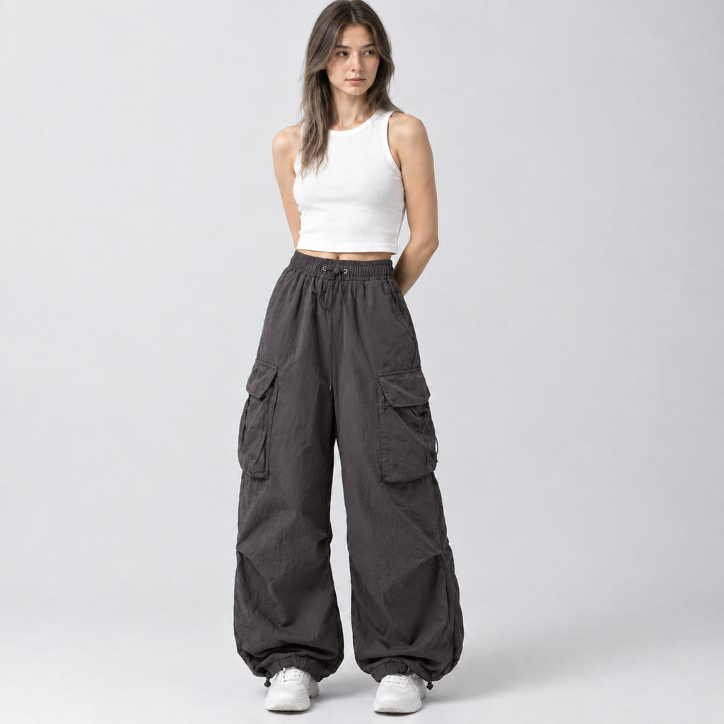 Gray wide-leg parachute cargo pants worn by a model in a neutral studio setting.