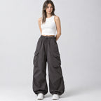 Gray wide-leg parachute cargo pants worn by a model in a neutral studio setting.