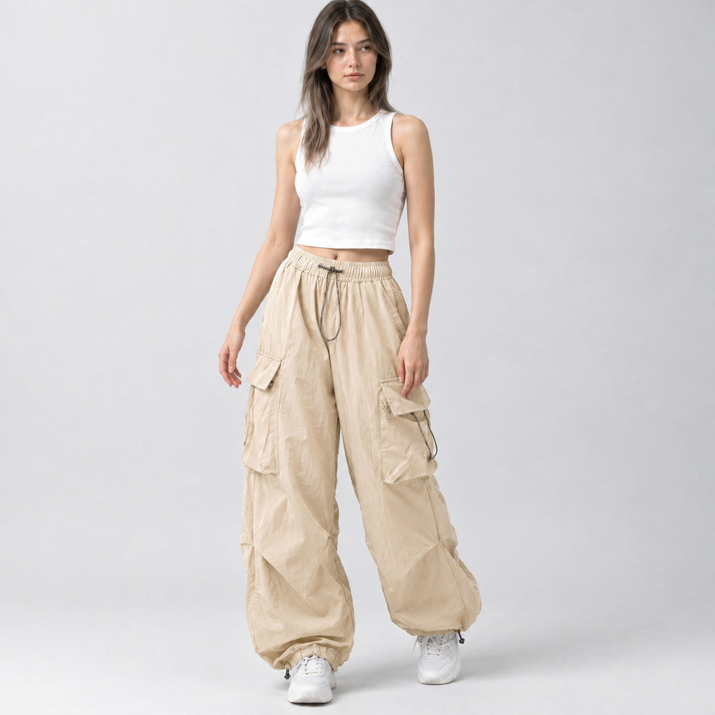Beige wide-leg parachute cargo pants worn by a model in a neutral studio setting.