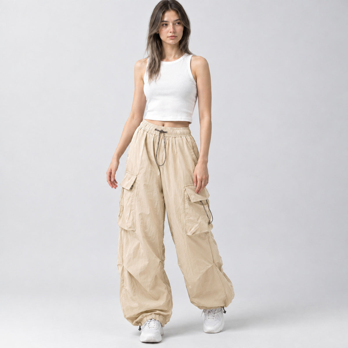 Beige wide-leg parachute cargo pants worn by a model in a neutral studio setting.