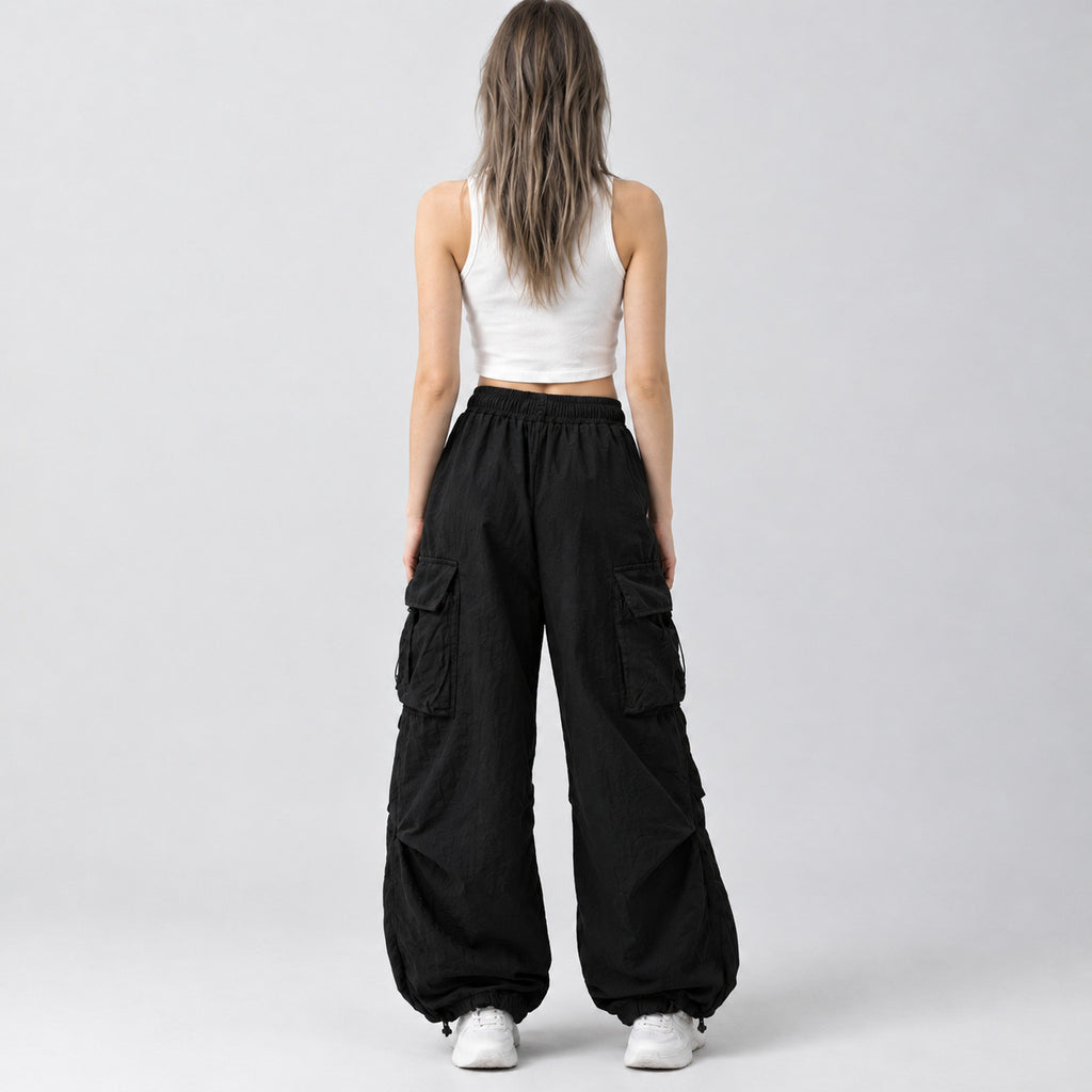 Back of the black wide-leg parachute cargo pants worn, showing the elastic waistband.