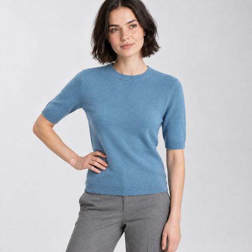 Soft blue crewneck half-sleeve sweater worn by a model in a neutral studio.