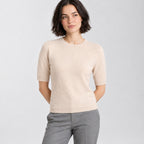 Light beige crewneck half-sleeve sweater worn by a model in a neutral studio.
