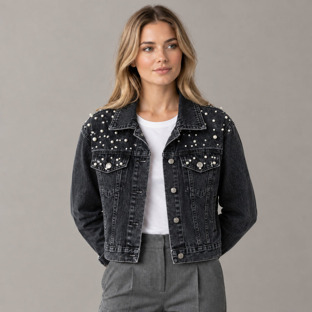 Black pearl-embellished denim jacket worn by a model in a neutral studio.