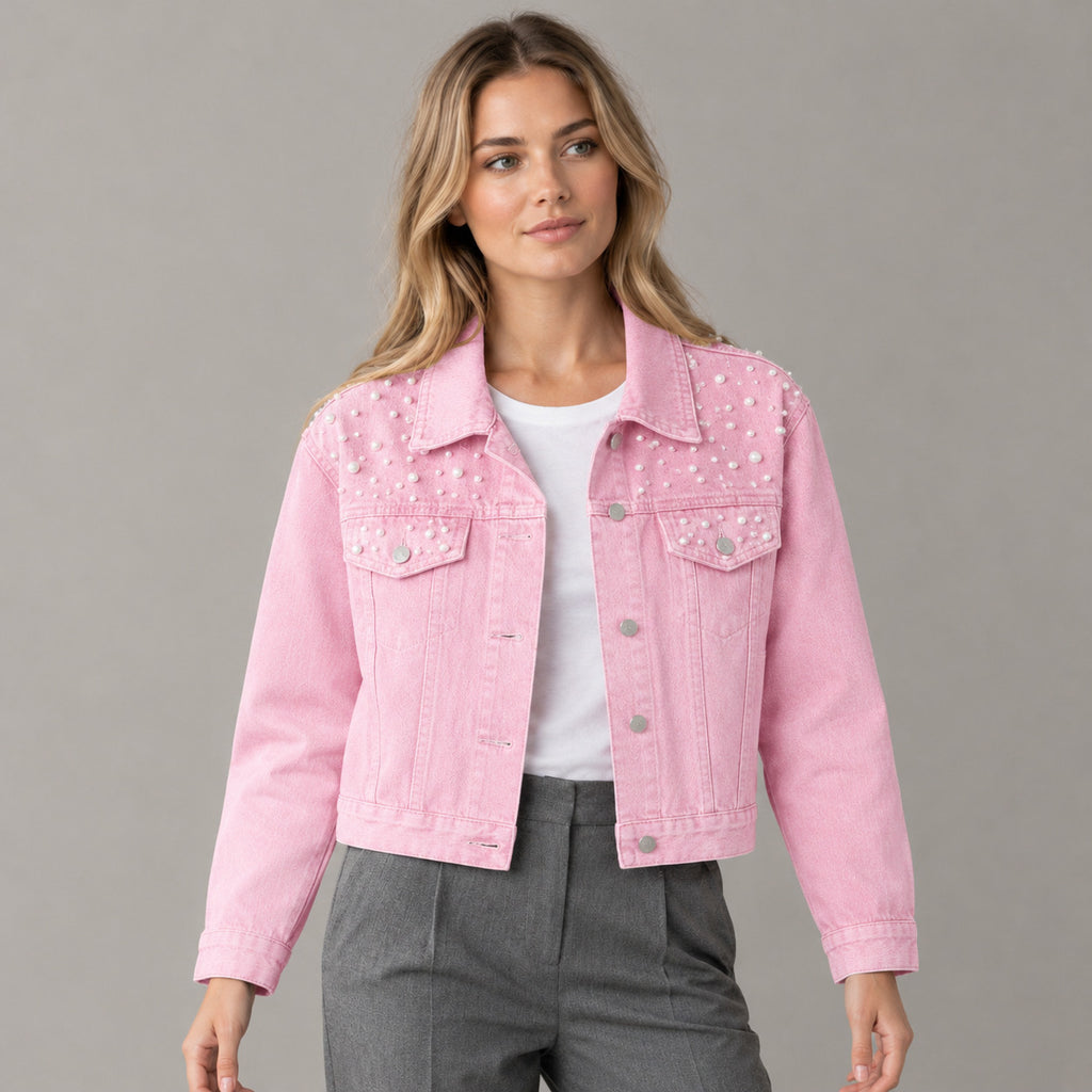 Pink pearl-embellished denim jacket worn by a model in a neutral studio.