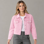 Pink pearl-embellished denim jacket worn by a model in a neutral studio.