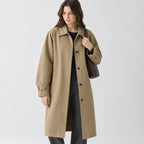 Khaki relaxed single-breasted trench coat worn by a model in a studio setting.