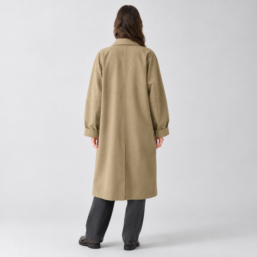 Back of the khaki relaxed single-breasted trench coat worn, showing the centre back seam.