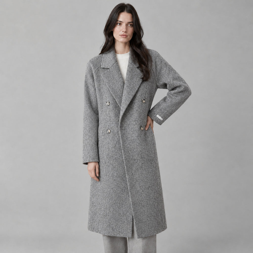 Snowflake gray double-breasted long wool coat worn by a model against a neutral studio backdrop.