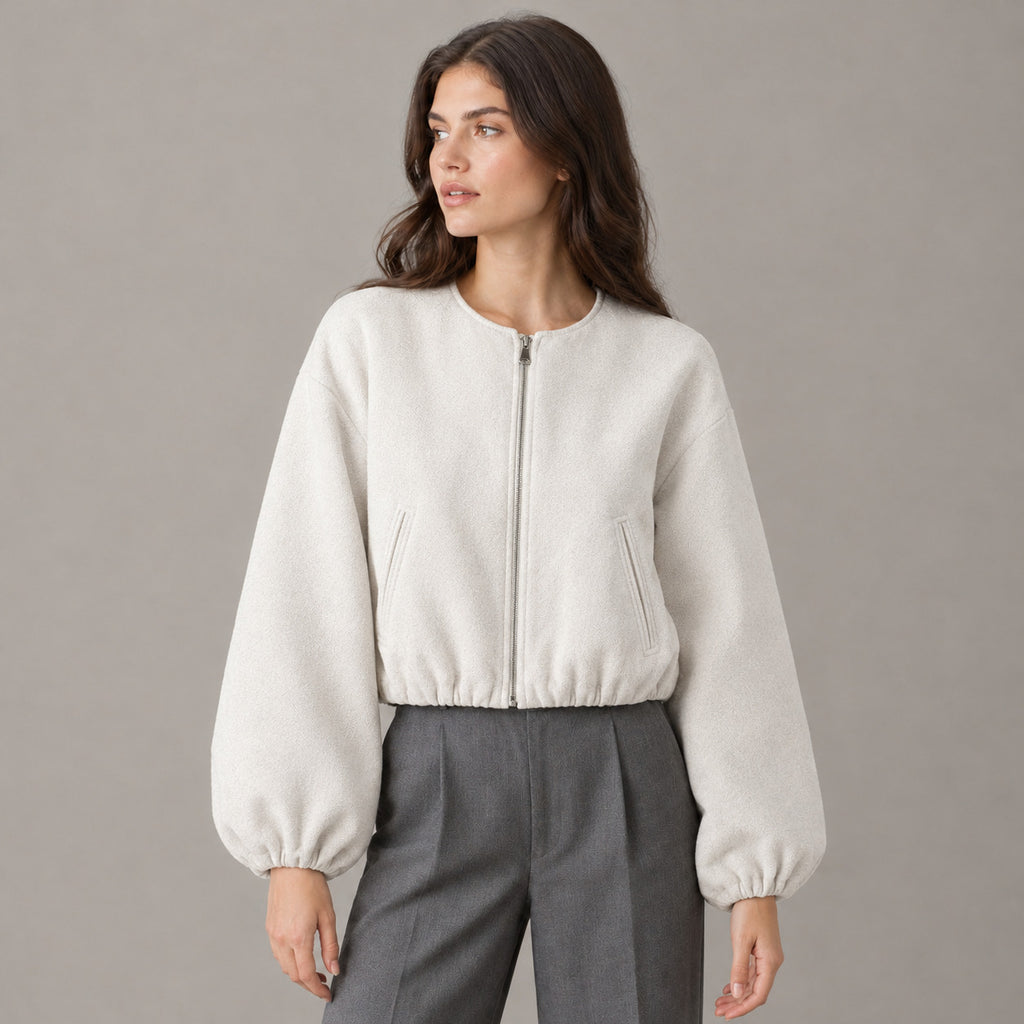 Off-white cropped collarless zip-up jacket worn by a model in a neutral studio.