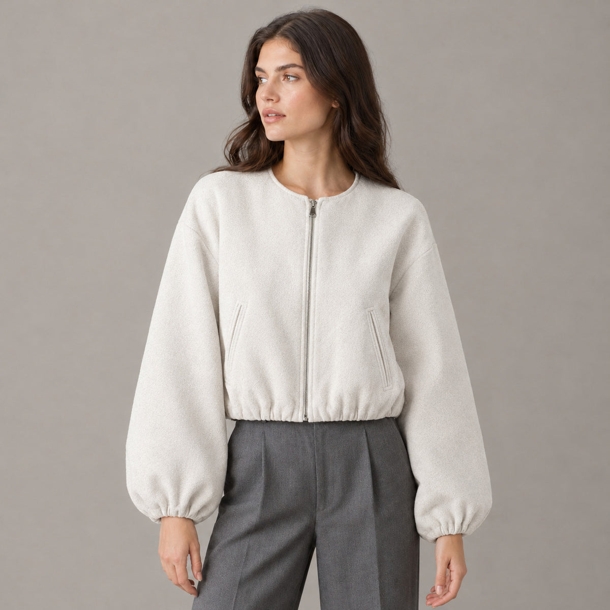 Off-white cropped collarless zip-up jacket worn by a model in a neutral studio.